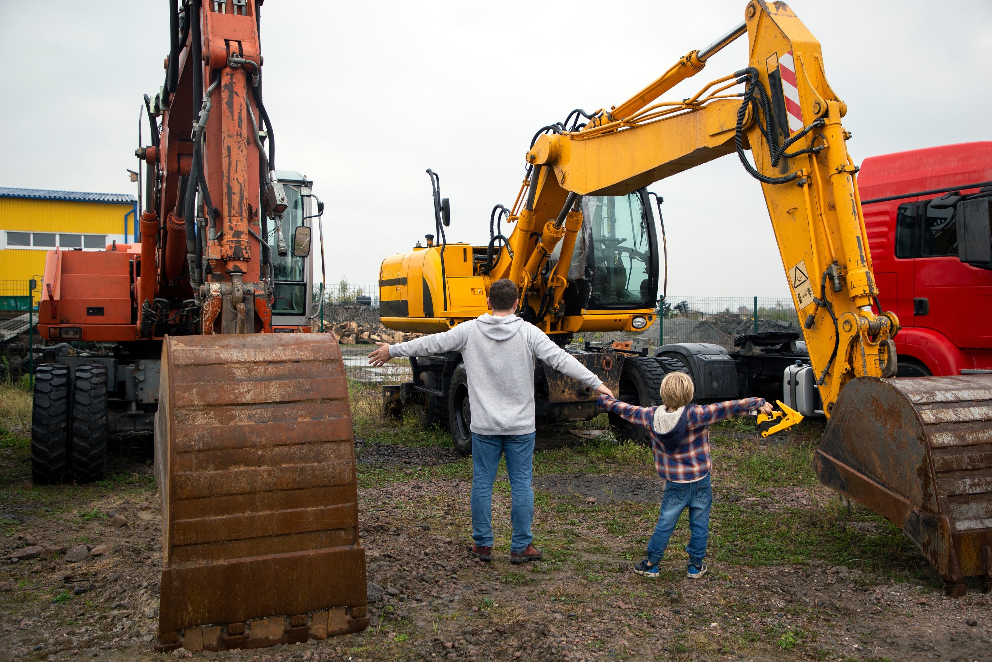 Dad and son working looking at excavators